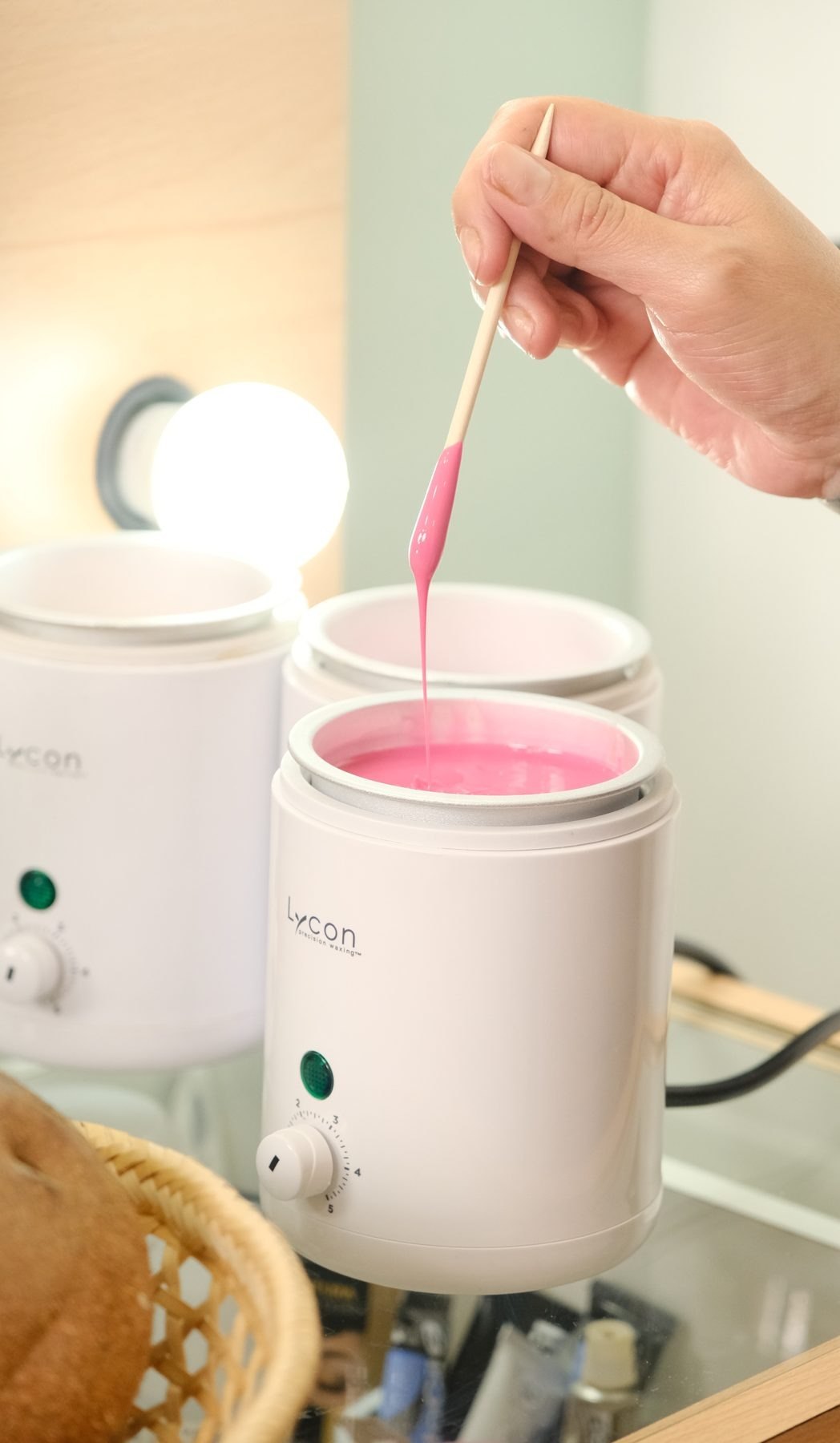 Preparación de cera rosa con espátula en la cabina
