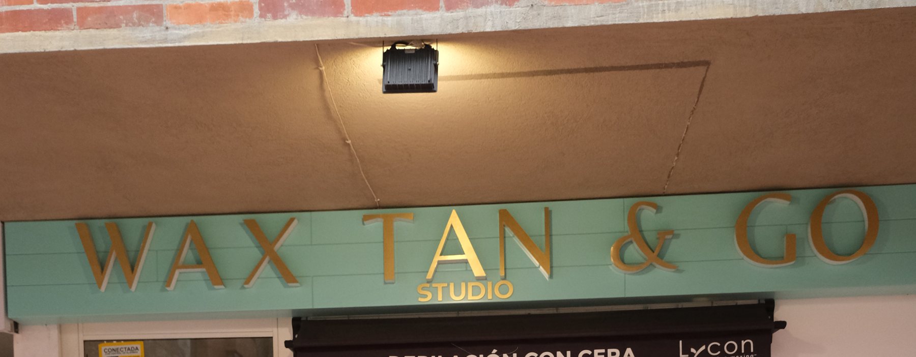 Letrero de Wax Tan & Go Studio en la fachada